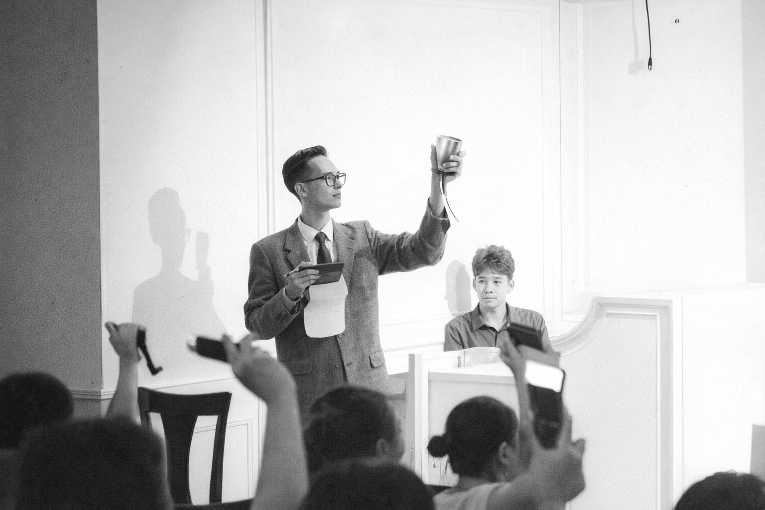 En auktionist håller upp ett föremål inför en publik under en auktion.